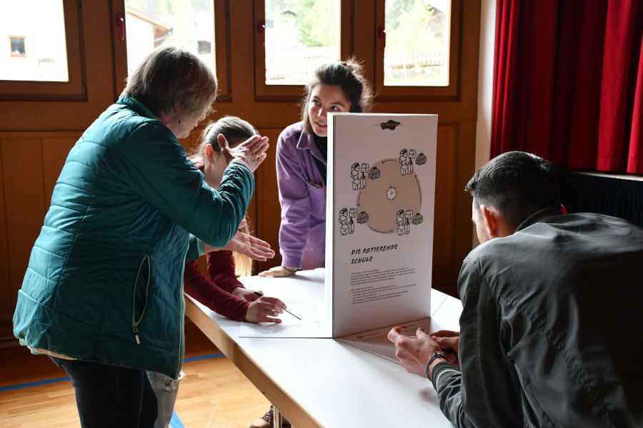 A picture that shows 5 adults discussing an idea at a table.